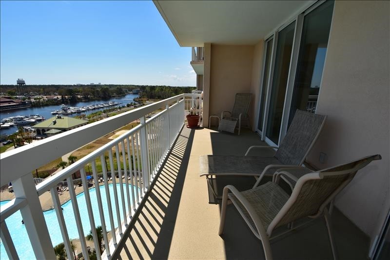 Balcony with view of water and pool.