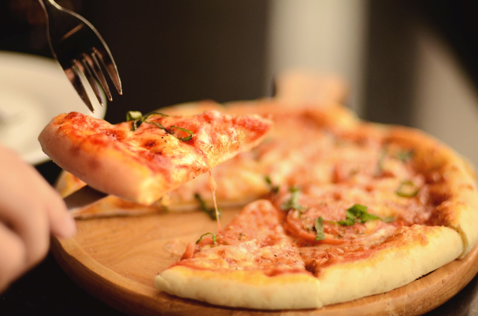 A pizza is being sliced.