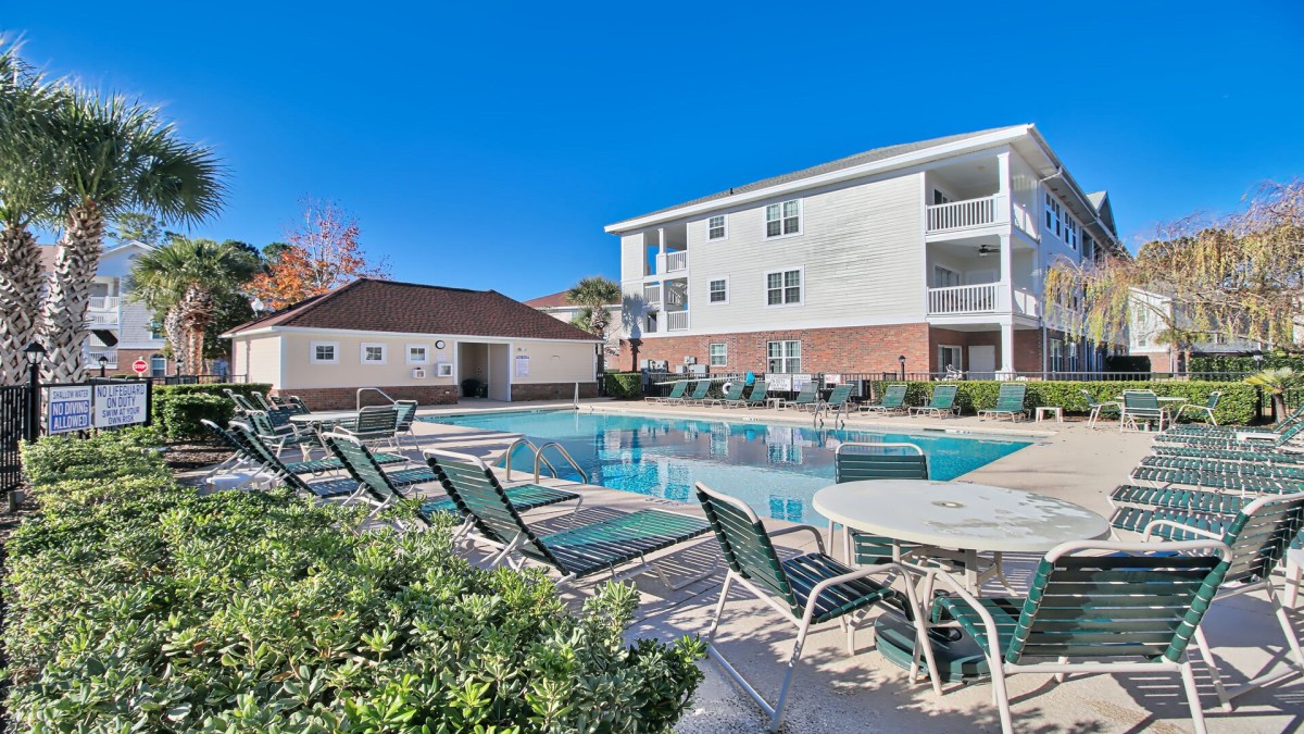 exterior of North Myrtle Beach condo rental, showcasing the pool and lounging area around the pool